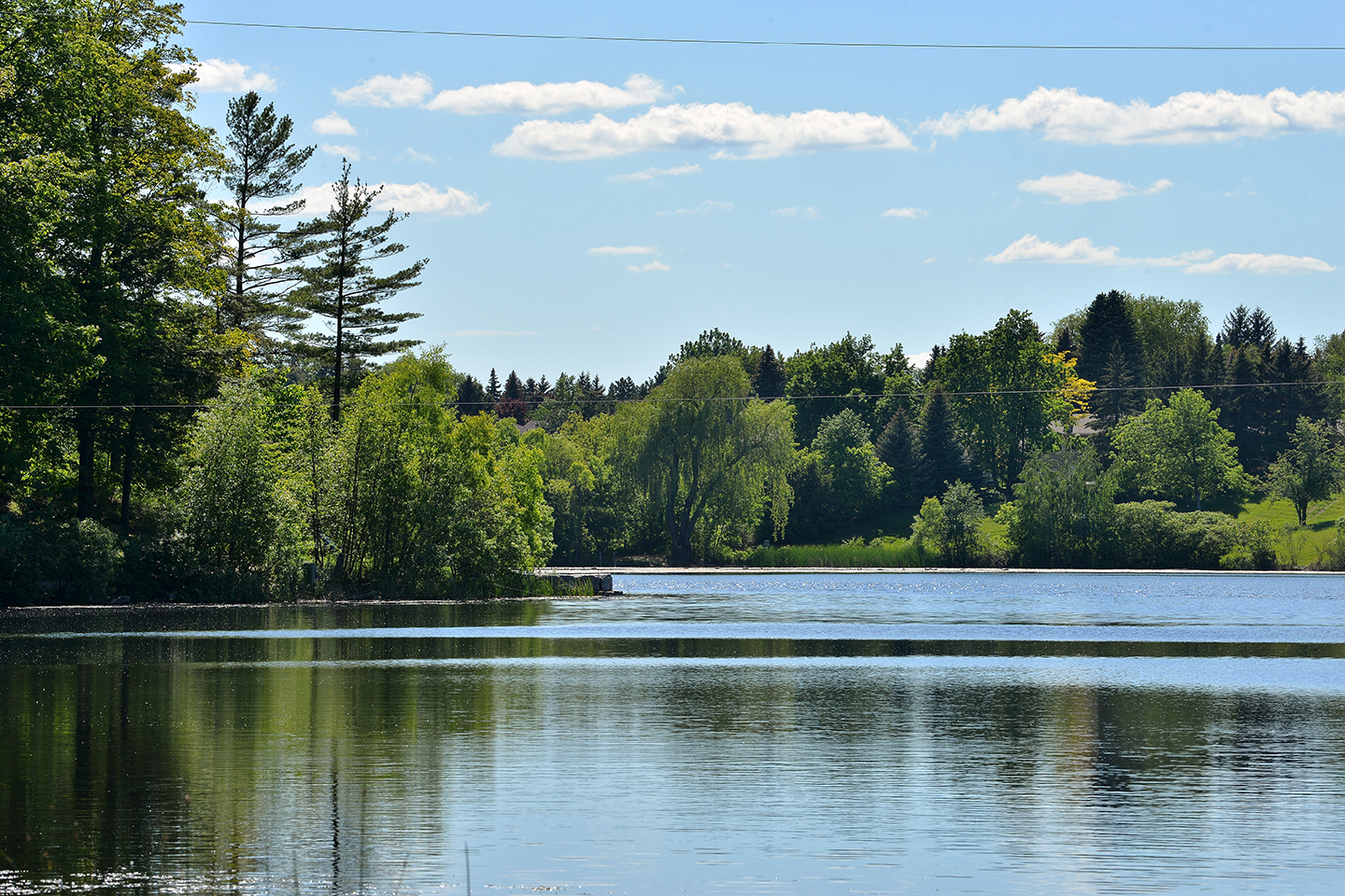 Heart Lake in Brampton, Ontario, with blue sky and green trees in the background.