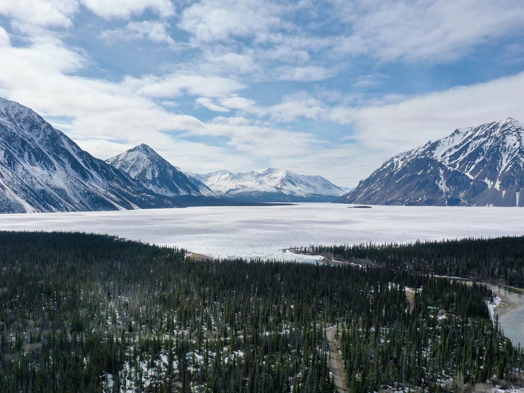 A stunning view of the frozen Kathleen Lake in Yukon Territory, Canada surrounded with snow-capped mountains