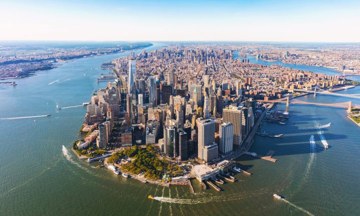 An aerial view of Manhattan looking up the Hudson and East Rivers with boats on the water