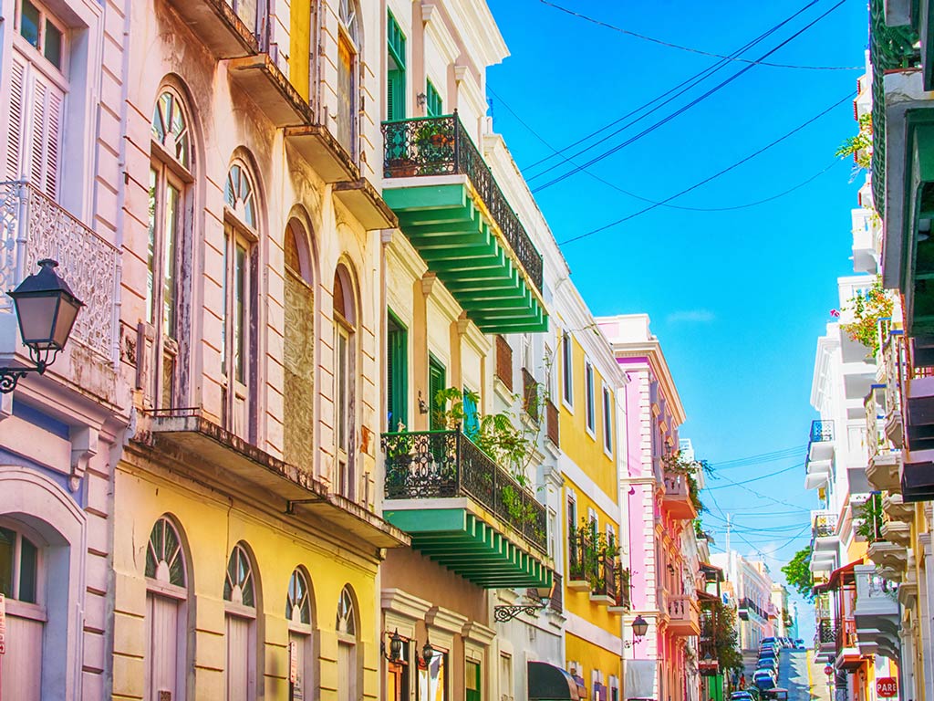 A typical street in Old San Juan, Puerto Rico, with colorful buildings and blue sky.