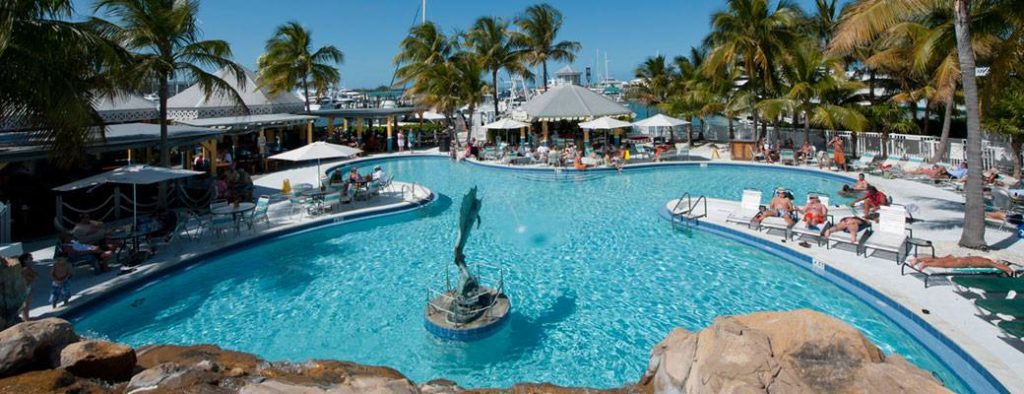 Dante's Restaurant Key West with a swimming pool and statue in the middle and people sunbathing around it on sun loungers