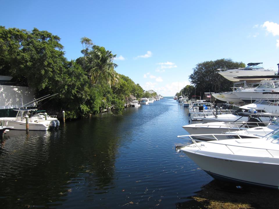 Boats lined up on either side of a canal in Key Largo on a sunny day
