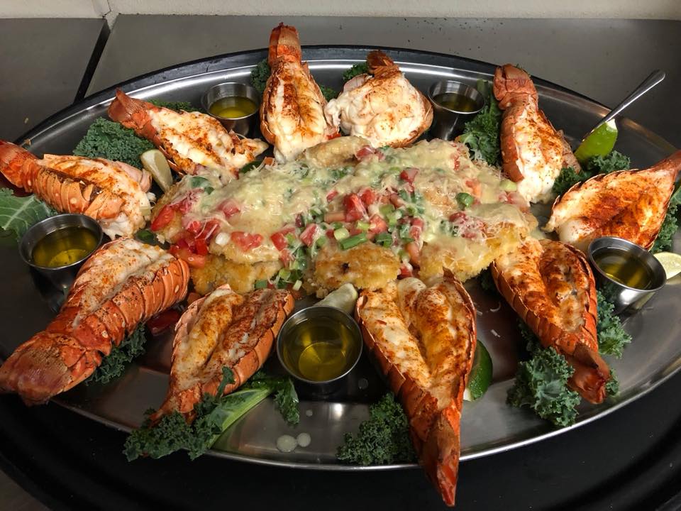 A seafood platter with melted cheese and salad in the middle at Lazy Days South in Marathon, FL