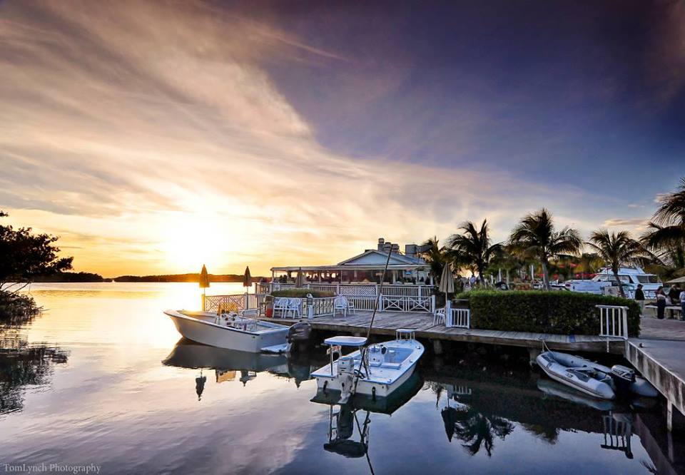 Boats docked up in the water next to Mile Marker 82, Islamorada, as the sun is setting