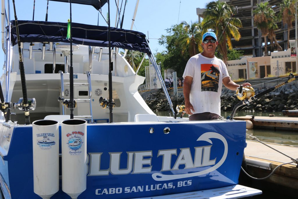 A Mexican charter fishing captain standing at the back of his boat in Cabo San Lucas.