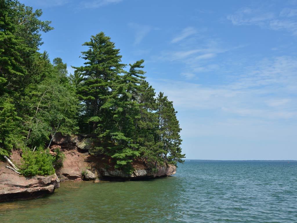 A view along Lake Superior, with green trees on the left