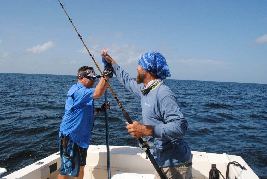 Angler and captain high five on the boat