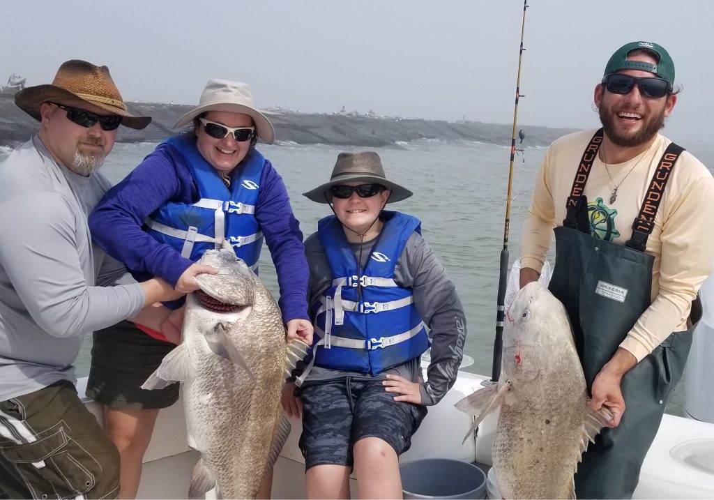 Family with 2 black drum fish in the winter