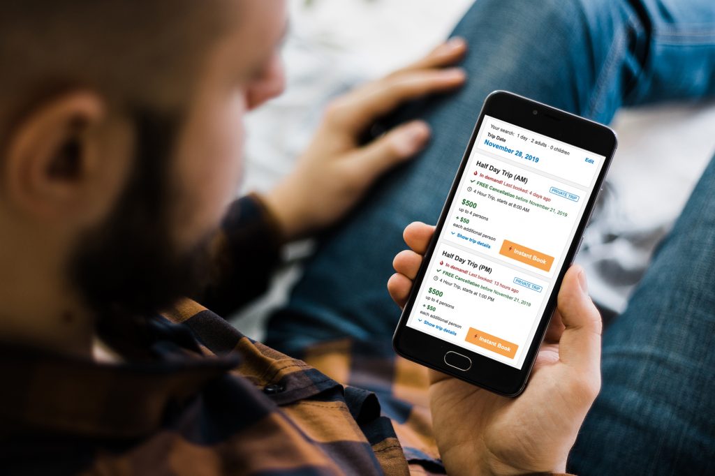 Man looking at a phone with Instant Book trips
