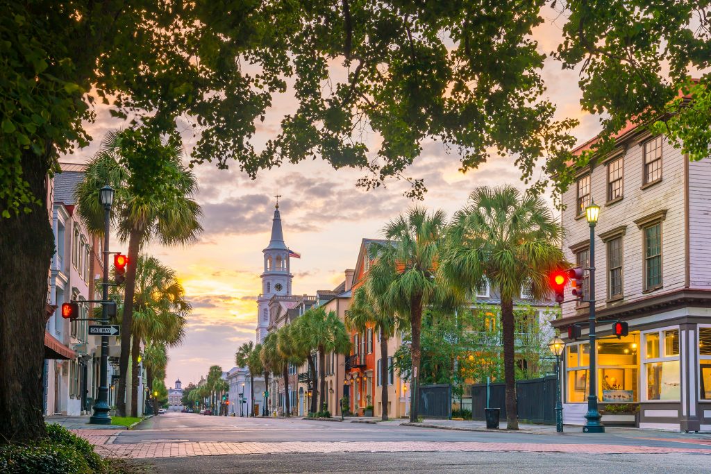 An old street in Charleson, SC, with Antebellum buildings and an old church in pink evening light