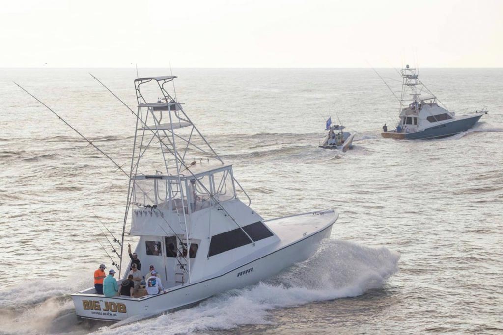 A view of two large sportfishing yachts and a smaller center console boat riding in the seas near Orange Beach, Alabama