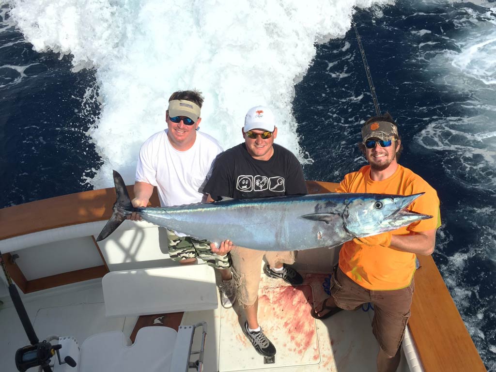 Three anglers with a big Wahoo caught offshore from Charleston