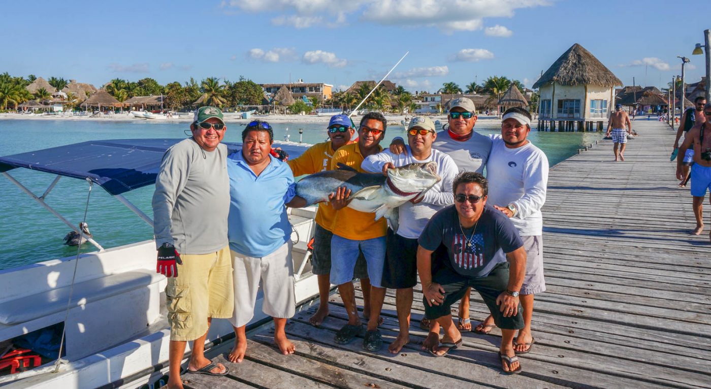 Anglers holding fish on the dock in Xcalak