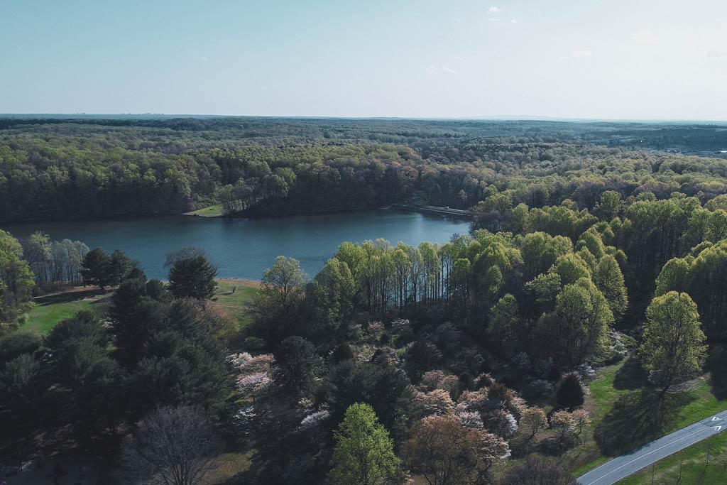 An aerial view of Clopper Lake in Seneca Creek State Park, surrounded by lush forests.