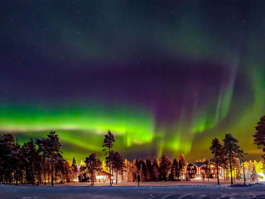 Northern lights with a town in the distance in Lapland, Finland