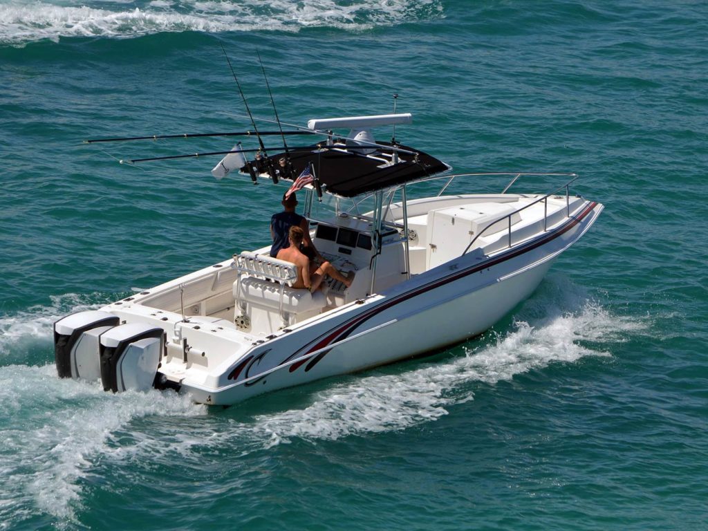 A white center console charter boat heading out to the fishing grounds with a pair of anglers on board