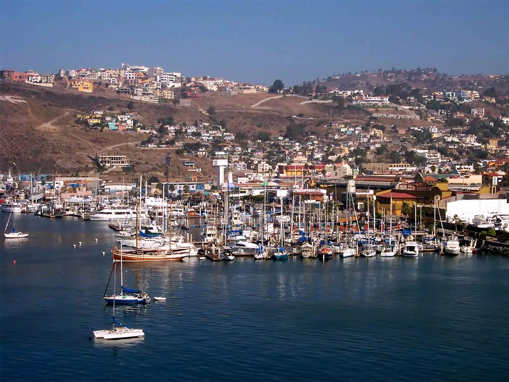 A view of Ensenada from the river with plenty of boats anchored in the harbor during a sunny day