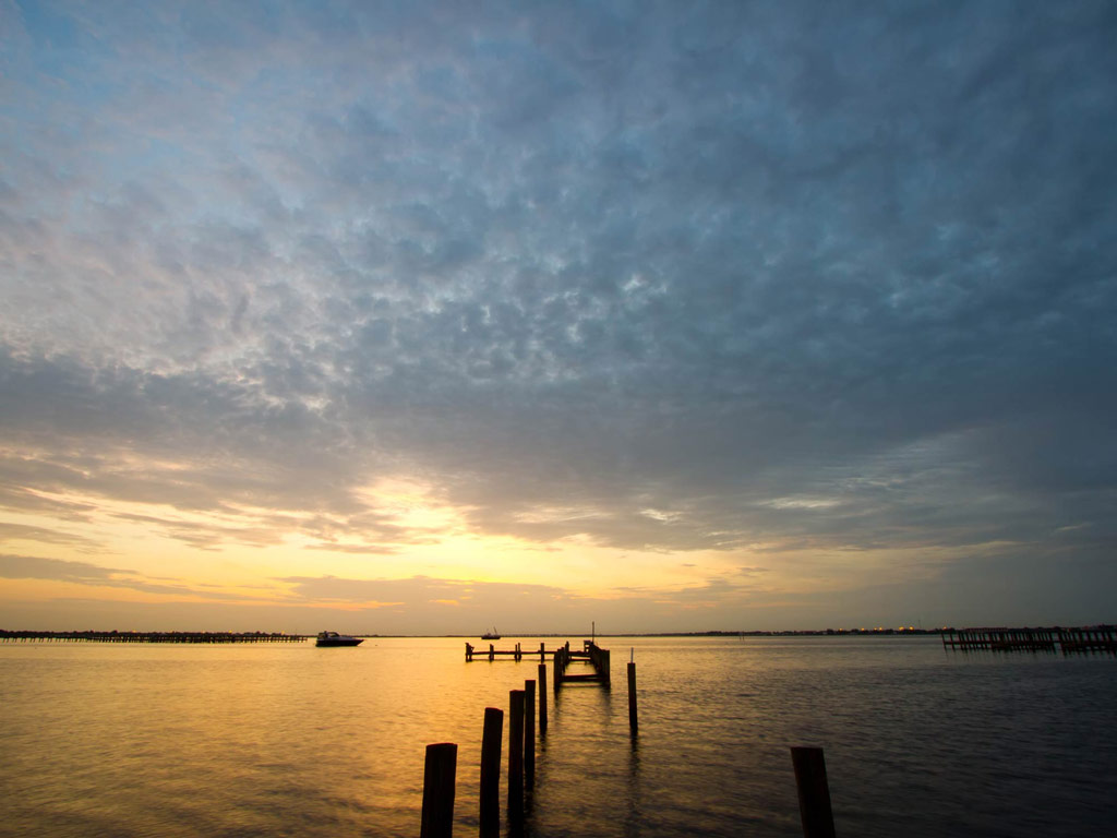 A shot of a sunset over Charlotte Harbor, with an old dock in the middle