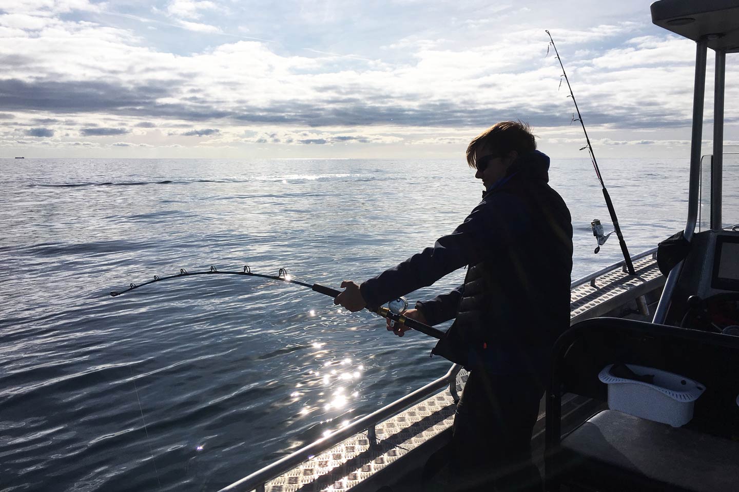 Ein Angler, der beim Jiggen in der Ostsee mit einer Meerforelle k&auml;mpft.
