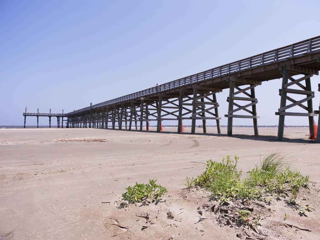 A view of the Marconi Fishing Pier located in City Park New Orleans and an empty sandy beach 