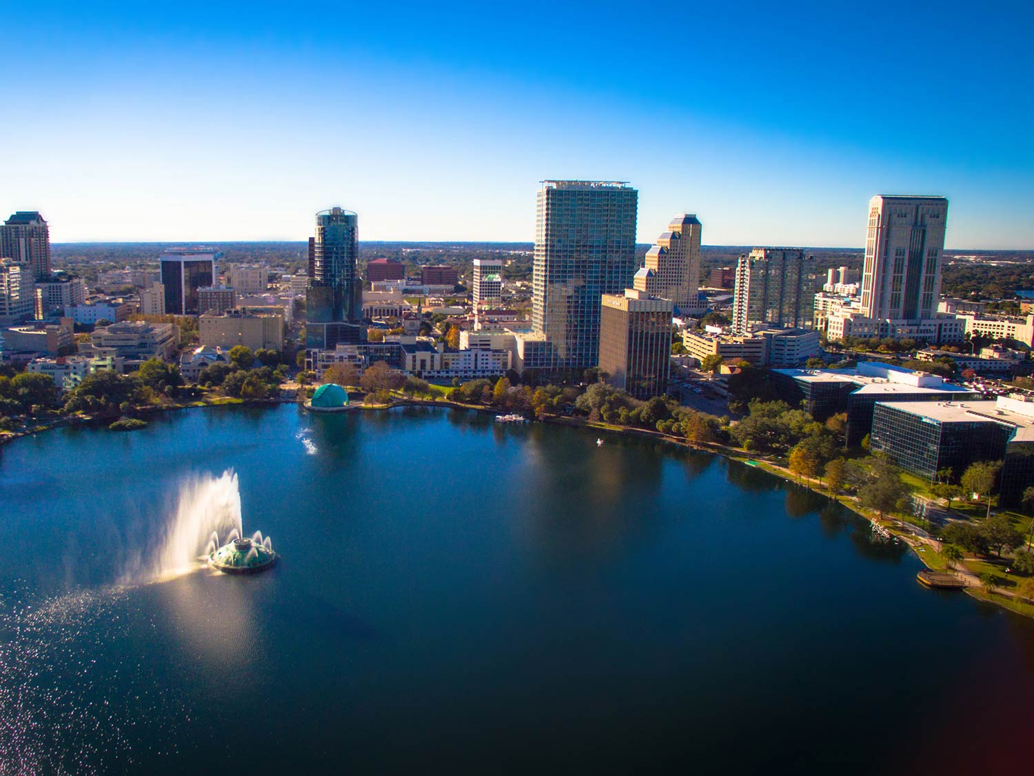 An aerial view of Orlando, with a large lake and tall buildings behind