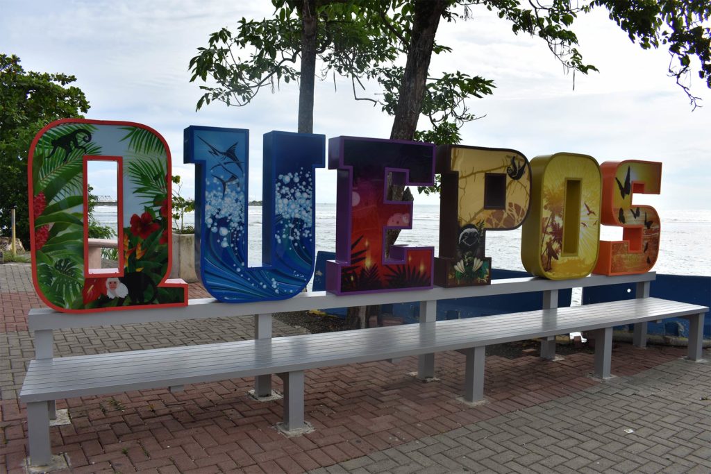 A sign with the town's name on the seafront in Quepos, Costa Rica