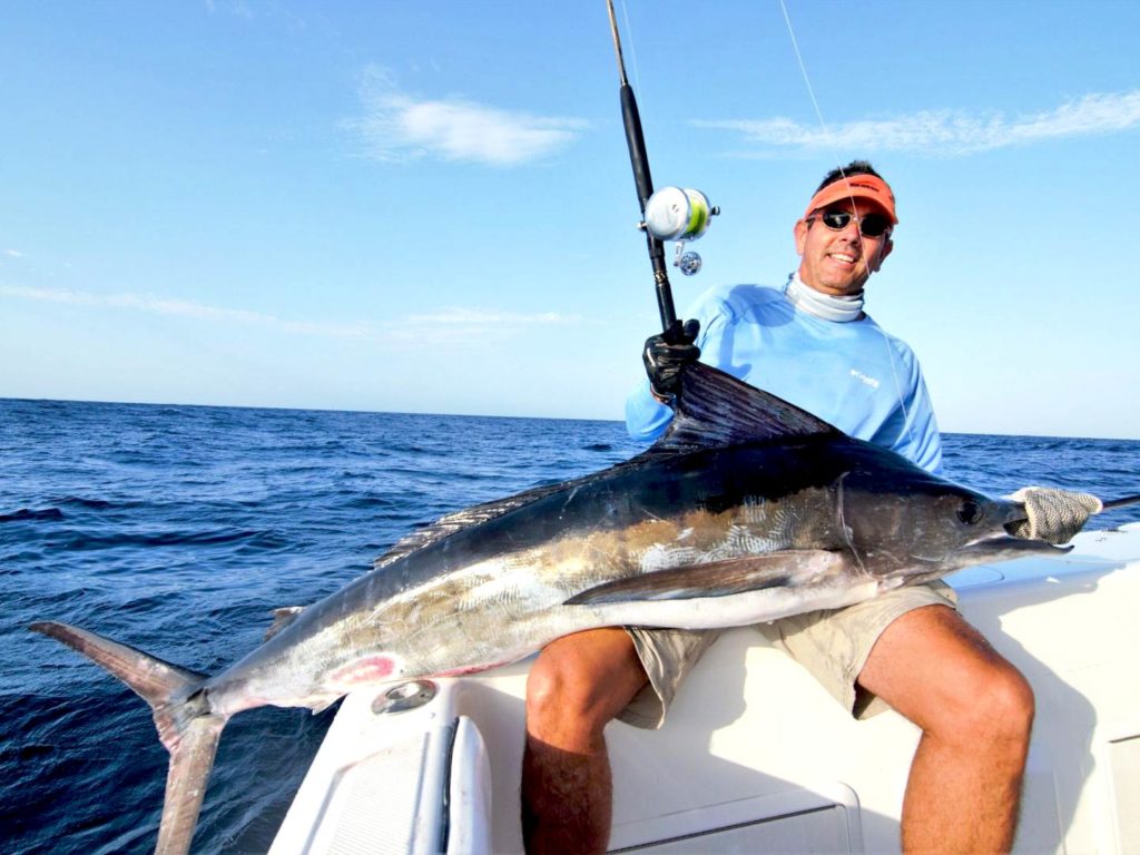A man holding a big Marlin on a boat in Texas