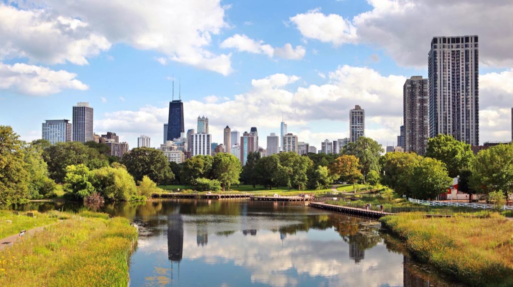 A view of Chicago's skyline on a sunny day, with the Lincoln Park Lagoon in view
