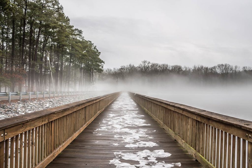 A pier leads to a frozen lake in winter in Virginia