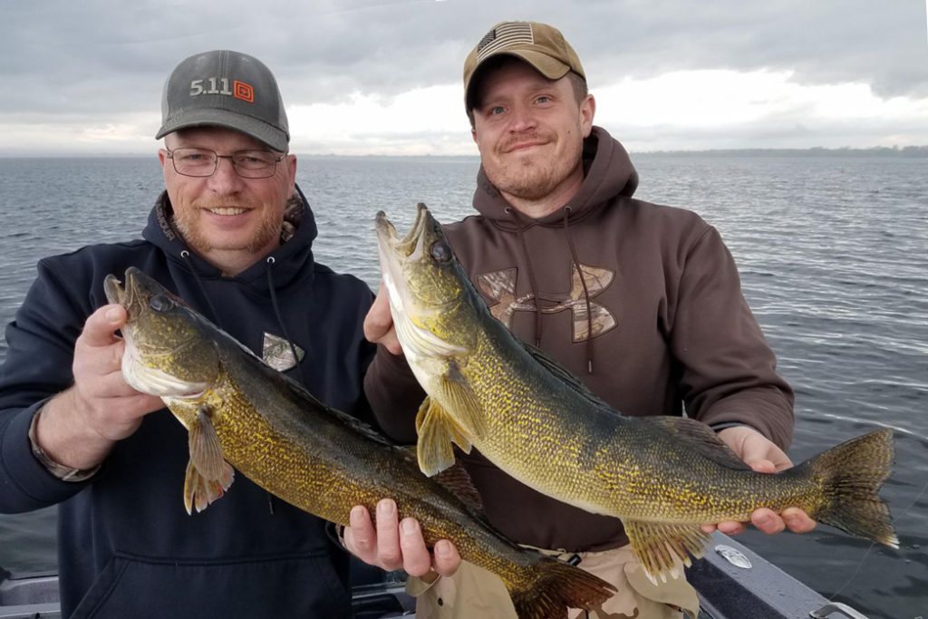 Two men hold a Walleye each on Lake Winnebago