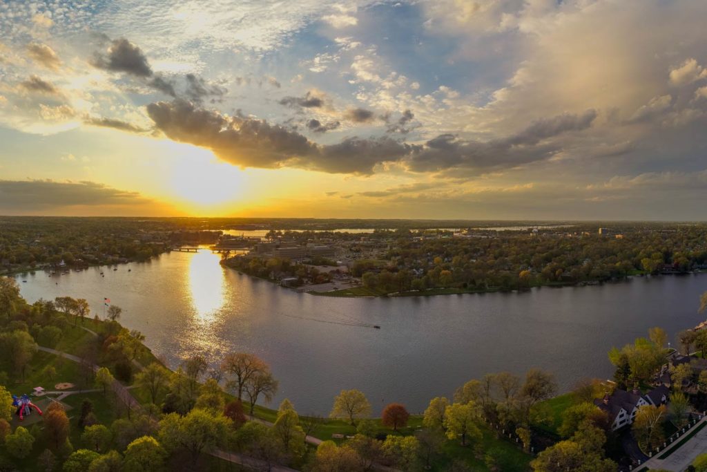 An aerial view of Lake Winnebago at sunset showing the lake, greenery, and the sky