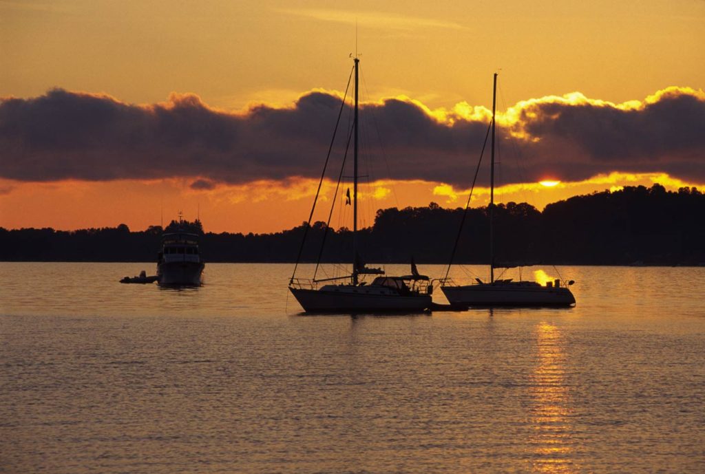 A view of Grand Traverse Bay at sunset with sailboats