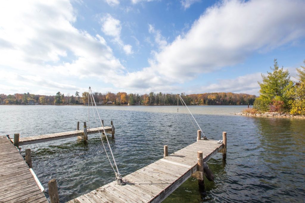A dock on Long Lake in Traverse City on a sunny day with the lake in the background