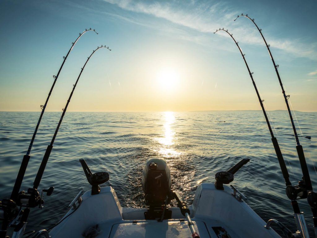 Four trolling fishing rods on a boat just after sunrise