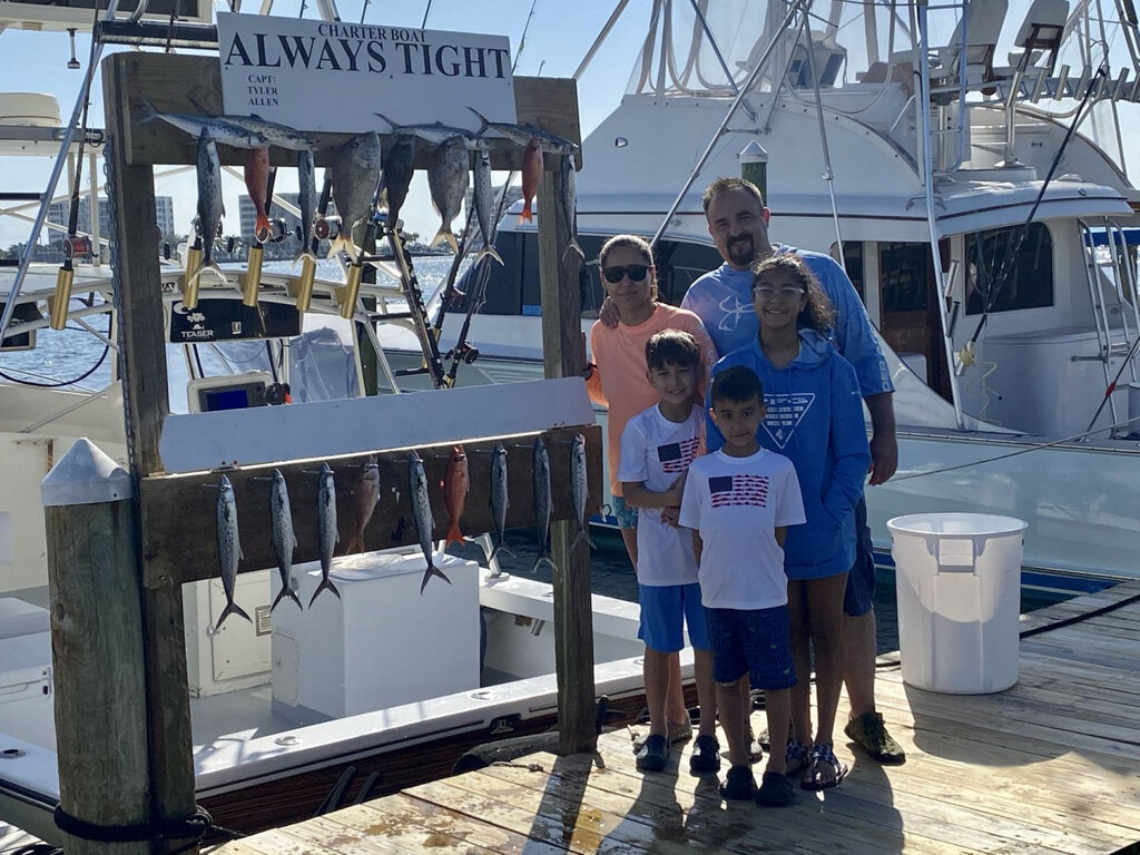 an angling family posing with their catch at the marina in Destin