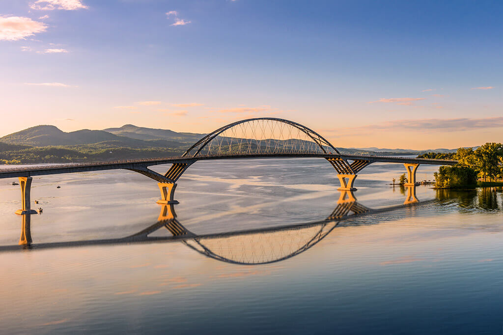 Lake Champlain Bridge at sunset, with mountains in the distance