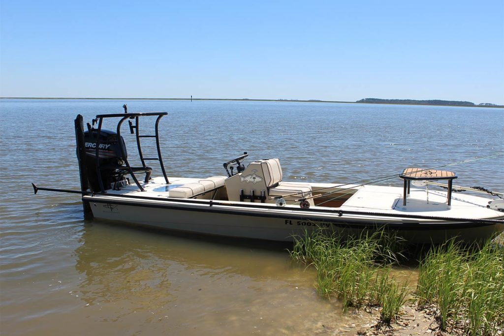 A fishing boat lies docked inshore in South Carolina with two fly fishing rods resting on board