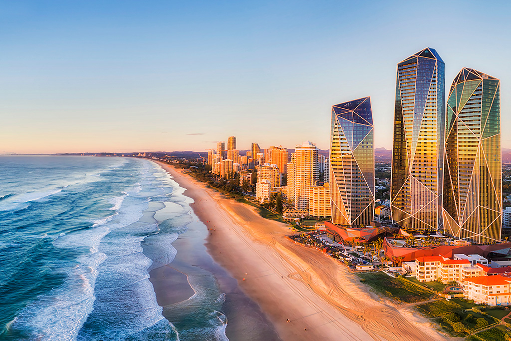 A view of the Gold Coast at sunset with the water to the left and the cityscape to the right