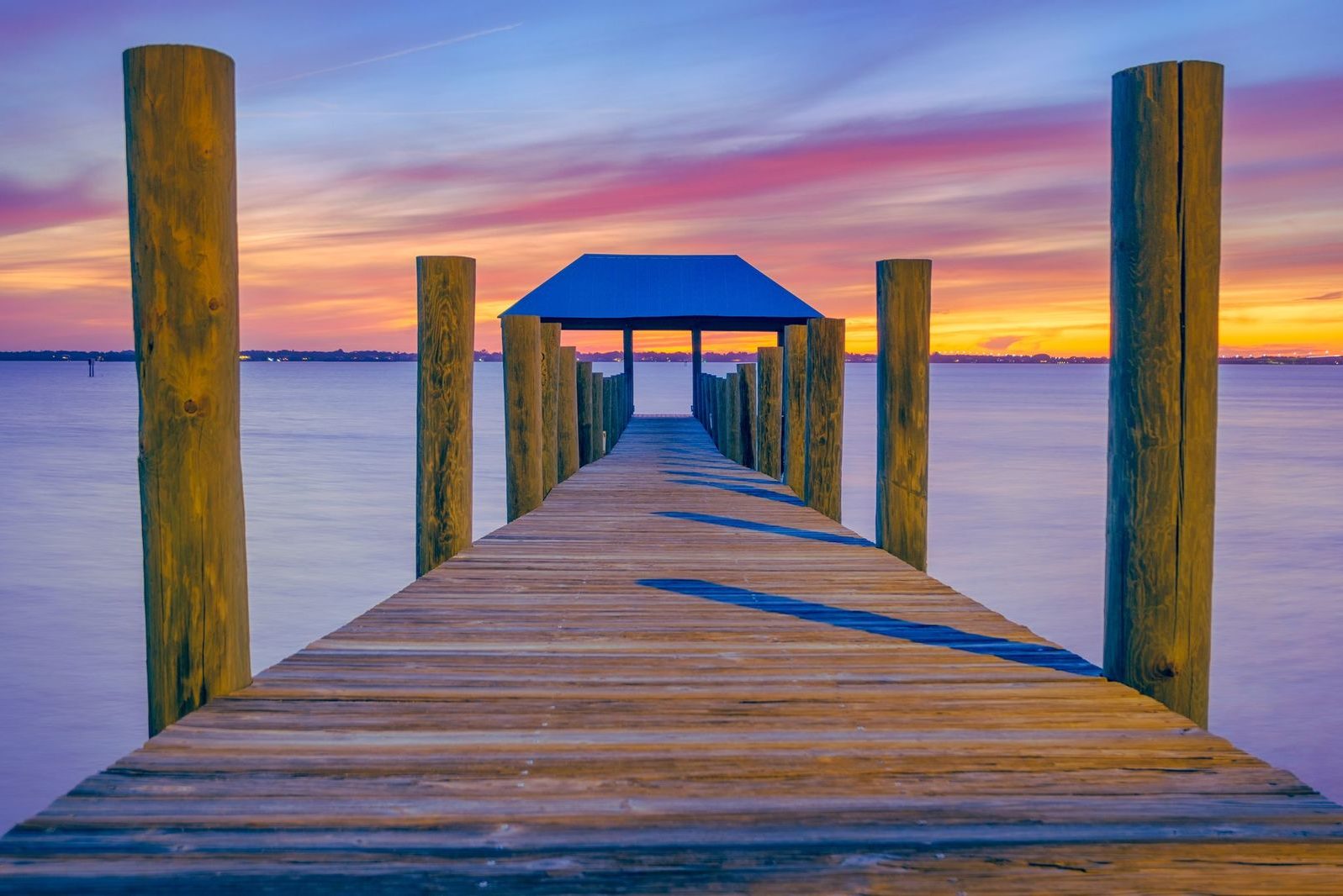 A sunset shot from a fishing pier on Hutchinson Island, one of the best summer fishing destinations in Martin County, Florida, with a refuge house at the end of the pier