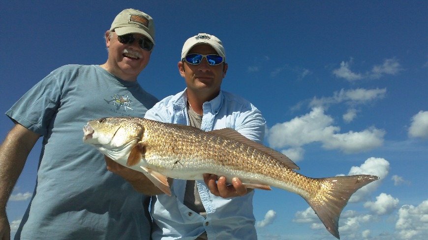 Captain Brian David holding a fish next to a smiling client