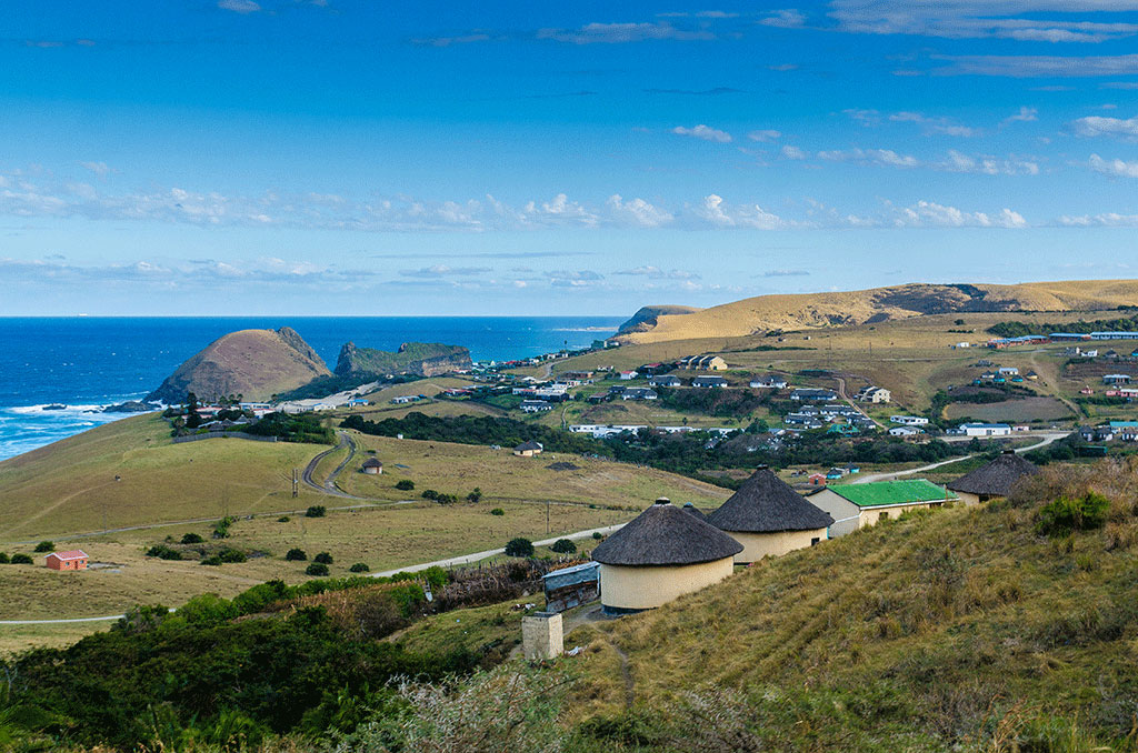 A view of South Africa's "Wild Coast" in Bulungula with some unusual farm houses in the foreground