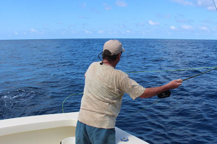 An angler casts a fly line in the deep seas 
