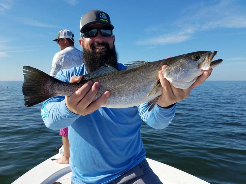 An angler holding a big Speckled Trout he caught while fishing in Louisiana.