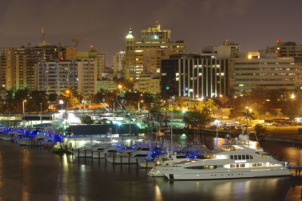 The skyline of San Juan, Puerto Rico at night with boats in the foreground