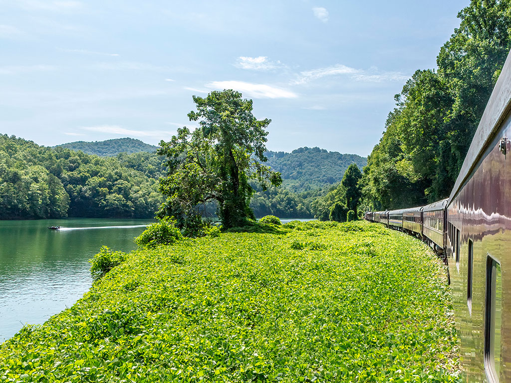 A train rides along a river in the Great Smoky Mountains in North Carolina