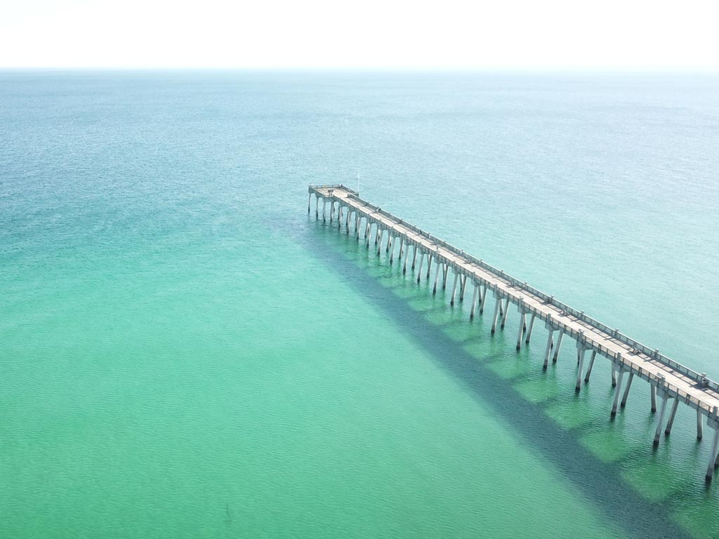 A photo of Pensacola Pier and the clear, aqua blue ocean waters.