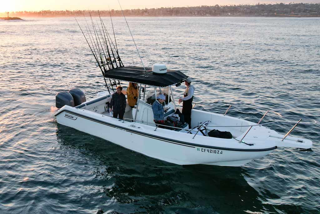 An anchored fishing boat on the water, with a crew of anglers on it