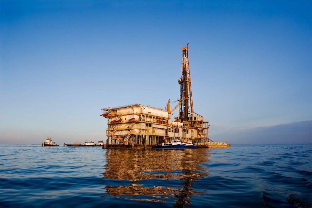 A view of an oil rig offshore from Galveston, Texas, at sunset on a sunny day