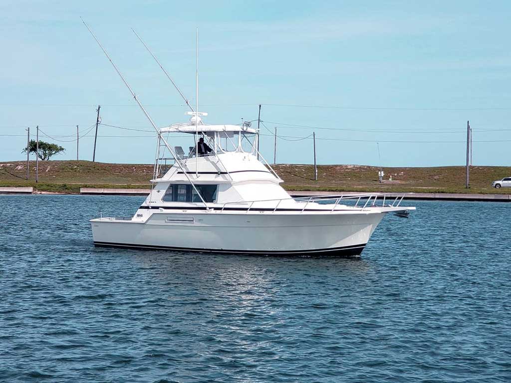 A photo of a deep sea fishing charter boat standing still on the water close to the shore somewhere in Texas.