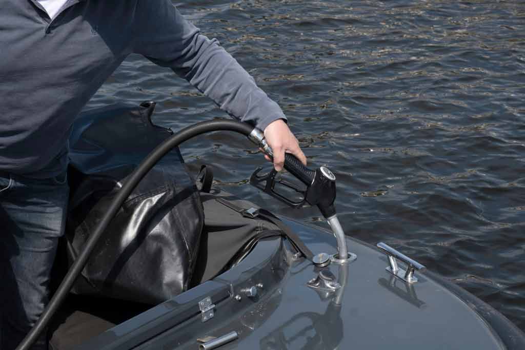 A man pouring fuel into his boat engine